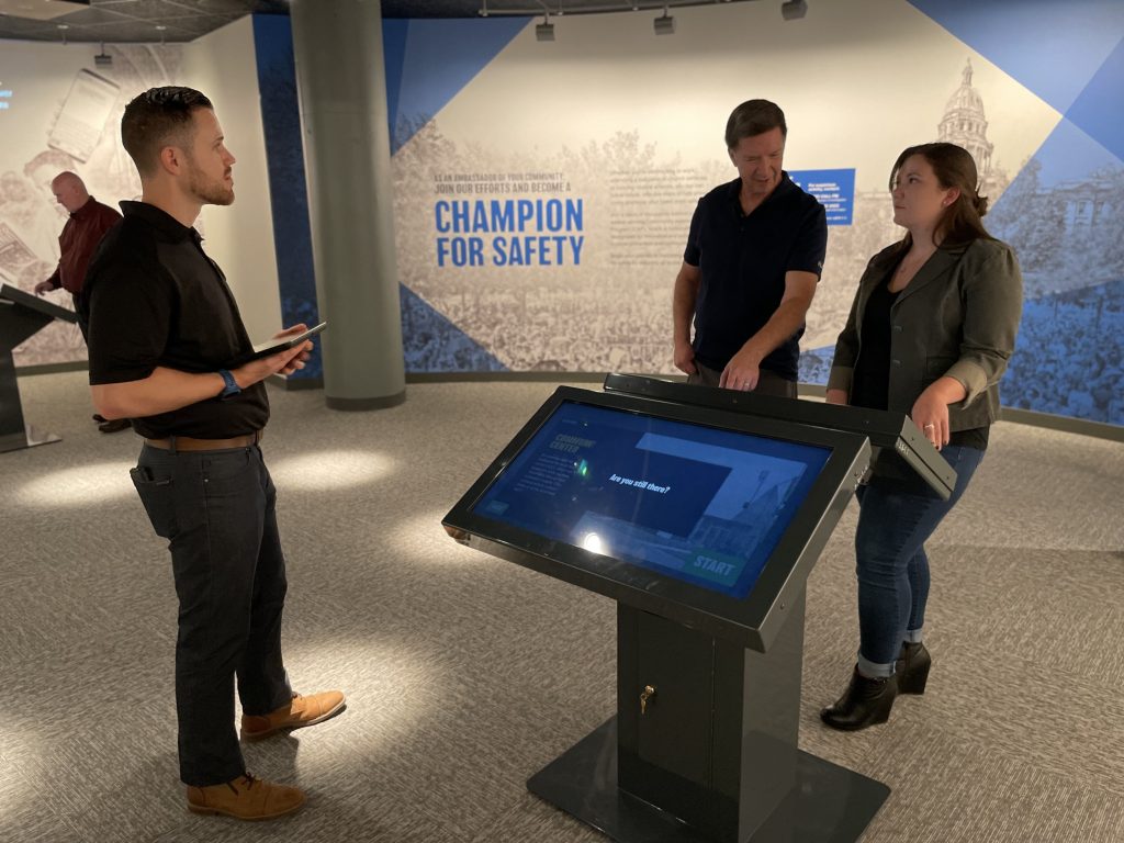 people in discussion around a digital information display at the CELL exhibit